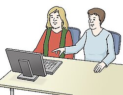 Zwei Menschen sehen auf einen Computer