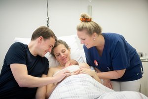 Eltern mit Neugeborenem und einer Mitarbeiterin