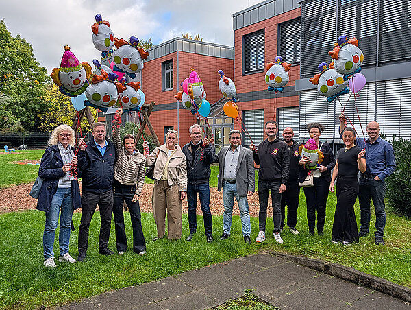 die Beteiligten mit großen Luftballons