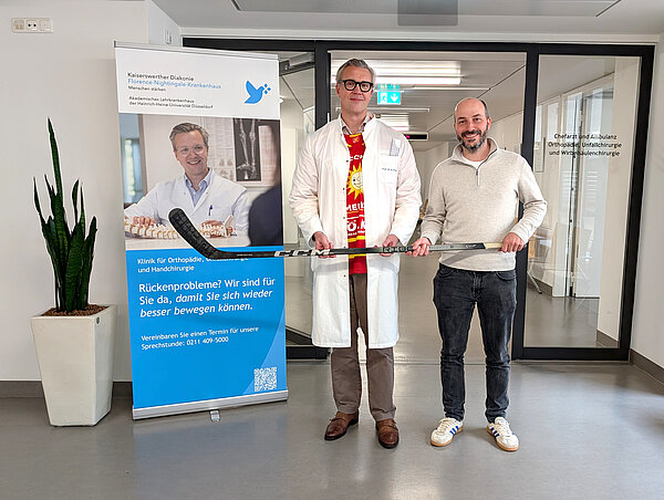 Chefarzt und DEG-Gesandter mit Eishockeystick