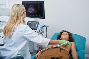Eine Ärztin macht einen Herzultraschall bei einem Jungen